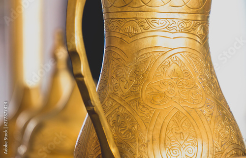 Close-up of golden arabic brass coffee pot. photo