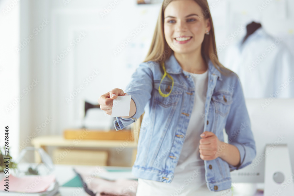 Beautiful young designer with business card in office Beautiful young designer with business card in office