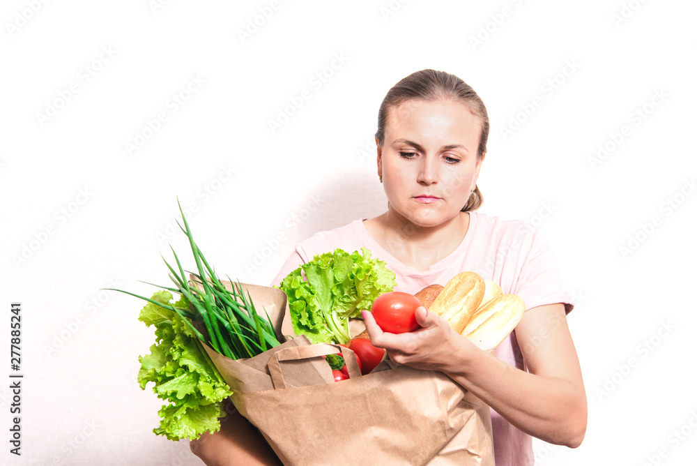 beautiful smiling woman holding a bag of groceries, standing on an isolated white background beautiful smiling woman holding a bag of groceries, standing on an isolated white background