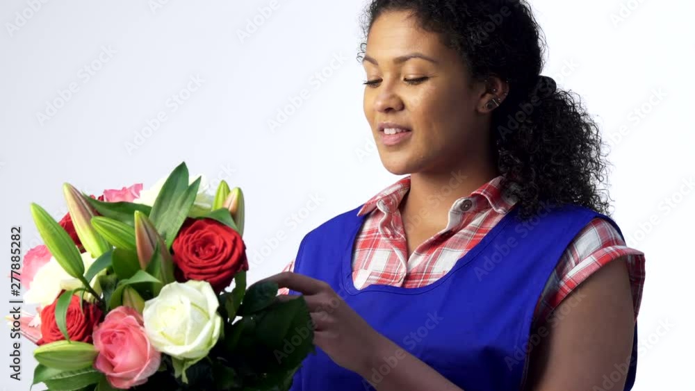 Studio Portrait Of Female Florist Arranging Bouquet Of Lilies And Roses Against White Background Studio Portrait Of Female Florist Arranging Bouquet Of Lilies And Roses Against White Background