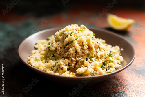 Traditional couscous with vegetables and herbs in a bowl. Levantine vegetarian salad. Lebanese, arabic cuisine. Close-up. Copy space