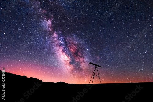 Silhouette of a telescope at the starry night and bright milky way galaxy. photo