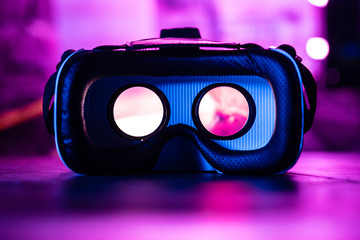 3d 360 vr headset glasses goggles lenses in futuristic purple neon light on table, virtual augmented ar reality innovative party experience digital mobile technology background concept, close up view