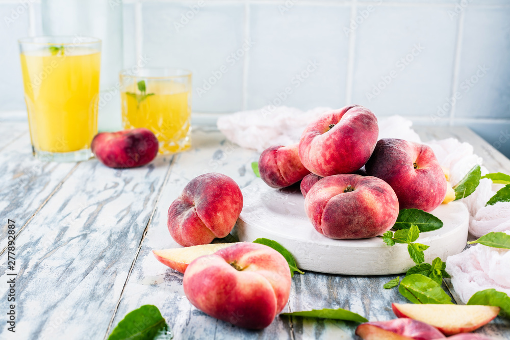 Ripe and Juicy peaches on table with fresh juice in background Ripe and Juicy peaches on table with fresh juice in background