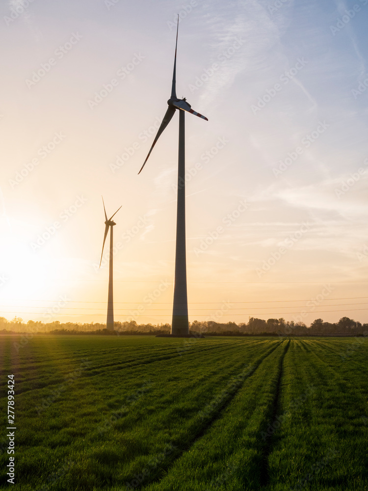 Obraz premium Windmill energy turbine at sunset