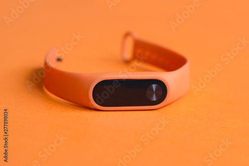 Wallpaper Mural Orange fitness tracker on an orange background close up. Torontodigital.ca