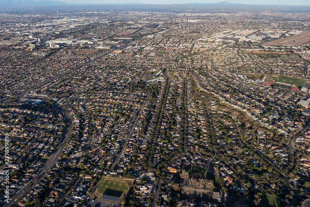 Aerial view of sprawling residential rooftops, streets and buildings in the Southbay area of Los Angeles County, California.