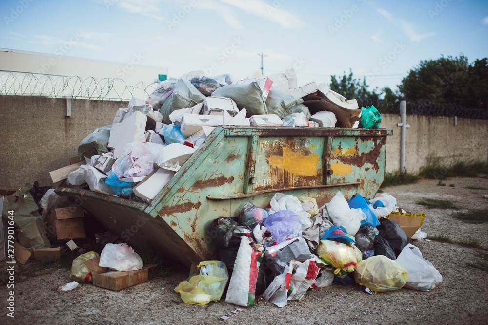 big garbage bin littered with waste.Bin, trash bag plastic waste