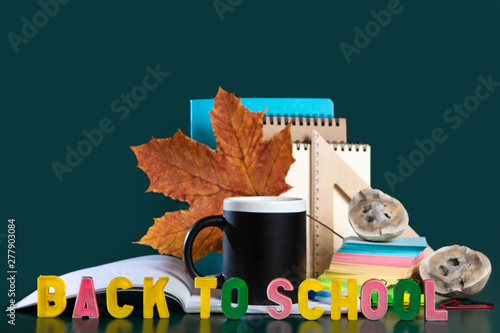Inscription BACK TO SCHOOL. Banner. Still life with school supplies. Green background. Notebooks, notebooks, felt-tip pens, colored pencils, an apple. Colorful picture. Copy space