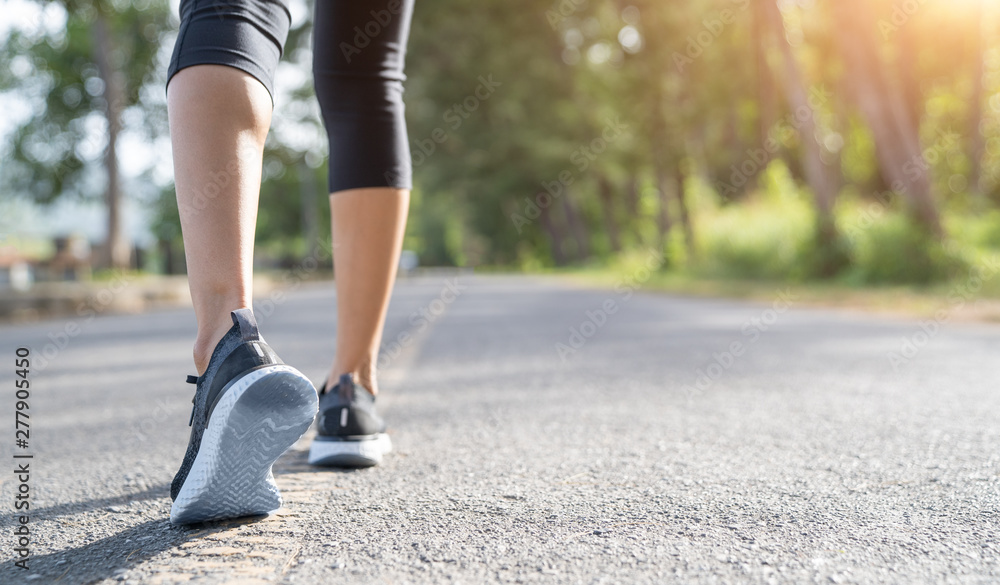 Runner feet running on road closeup on shoe. Woman fitness sunrise jog workout wellness concept. Young fitness woman runner athlete running at road Runner feet running on road closeup on shoe. Woman fitness sunrise jog workout wellness concept. Young fitness woman runner athlete running at road