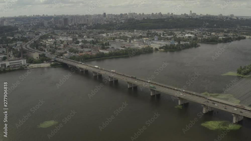Aerial Shot drone view Flying along the south bridge in Kiev, Ukraine, where a grass car and water around it Aerial Shot drone view Flying along the south bridge in Kiev, Ukraine, where a grass car and water around it