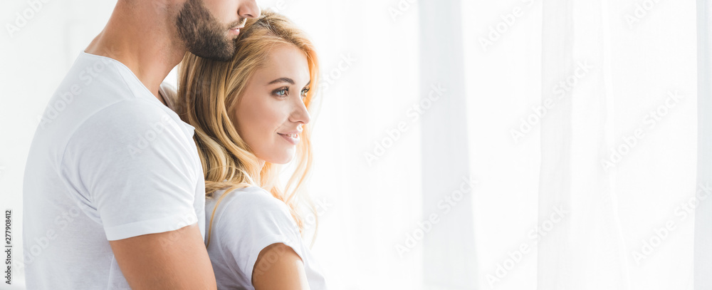 panoramic shot of beautiful couple hugging at home in morning with sunlight panoramic shot of beautiful couple hugging at home in morning with sunlight