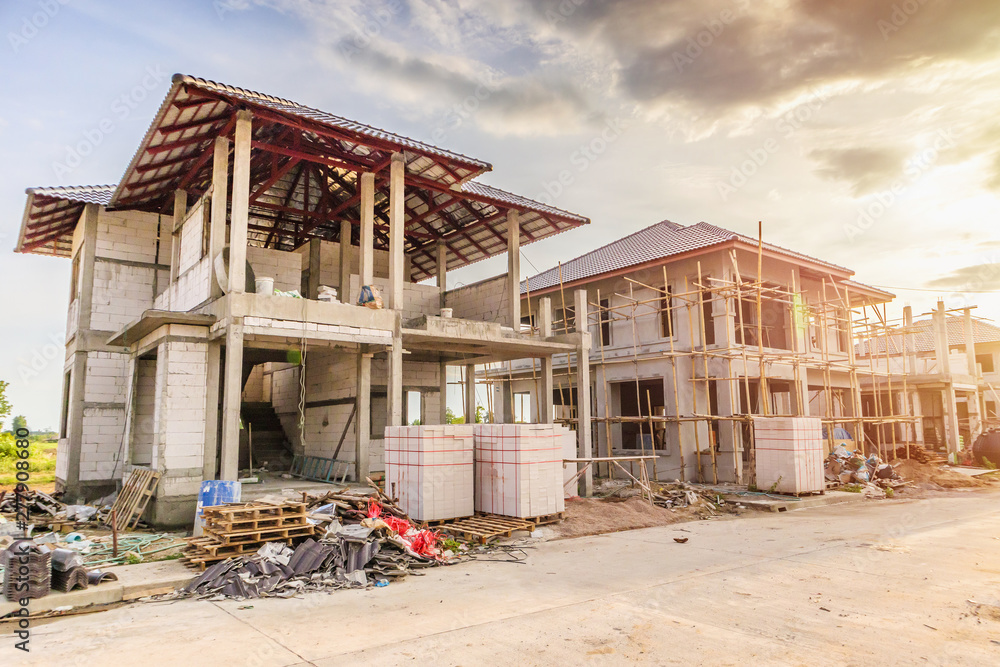 Obraz premium construction residential new house in progress at building site with clouds and blue sky