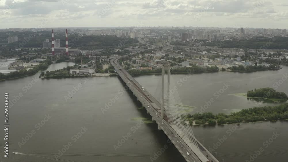 Aerial Shot drone view Flying along the south bridge in Kiev, Ukraine, where a grass car and water around it Aerial Shot drone view Flying along the south bridge in Kiev, Ukraine, where a grass car and water around it