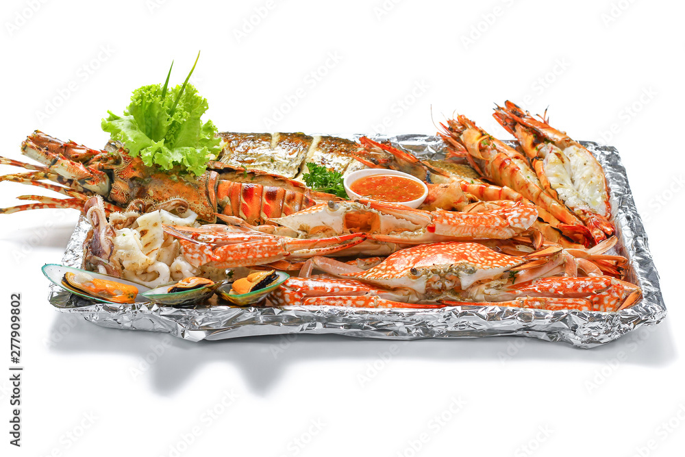 Grilled Mixed Seafood Big Set: Lobster Fish Blue Clabs Big Shrimps Mussels Clams Calamari Squids with pieces of lemon & vegetable on white background with shadow Macro Close up low angle side view. Grilled Mixed Seafood Big Set: Lobster Fish Blue Clabs Big Shrimps Mussels Clams Calamari Squids with pieces of lemon & vegetable on white background with shadow Macro Close up low angle side view.