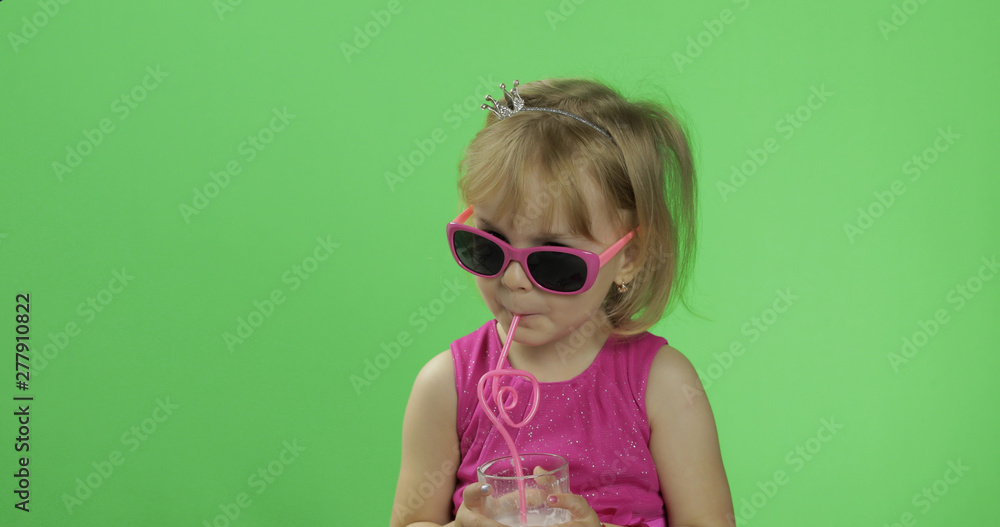 Happy four years old child in pink dress drinks milkshake cocktail. Chroma Key
