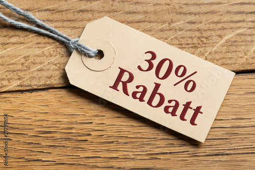 Hangtag mit Aufschrift "30% Rabatt" auf Holzhintergrund 