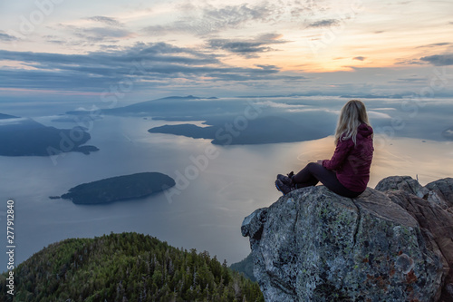 Adventurous Female Hiker on top of a mountain covered in clouds during a vibrant summer sunset. Taken on top of St Mark's Summit, West Vancouver, British Columbia, Canada. © edb3_16