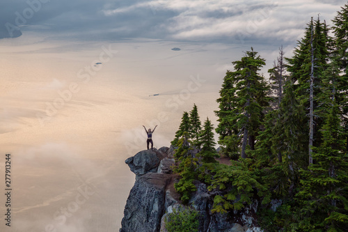 Female Hiker on top of a mountain covered in clouds during a vibrant summer sunset. Taken on top of St Mark's Summit, West Vancouver, British Columbia, Canada. © edb3_16