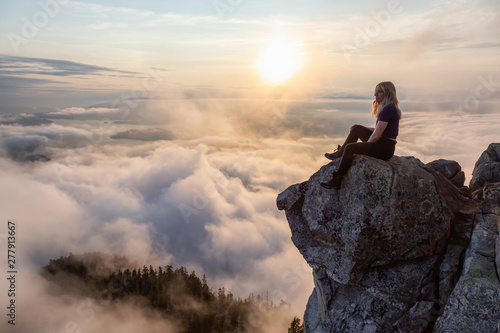 Adventurous Female Hiker on top of a mountain covered in clouds during a vibrant summer sunset. Taken on top of St Mark's Summit, West Vancouver, British Columbia, Canada. © edb3_16