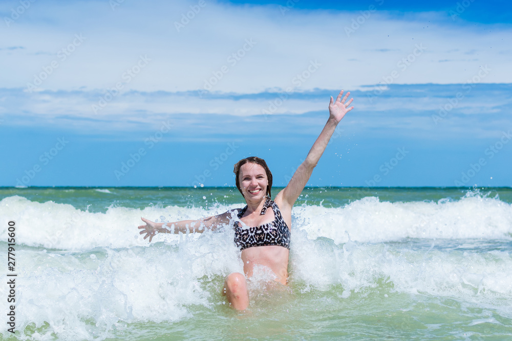 A joyful, contented middle-aged woman swims in the sea in waves. A joyful, contented middle-aged woman swims in the sea in waves.