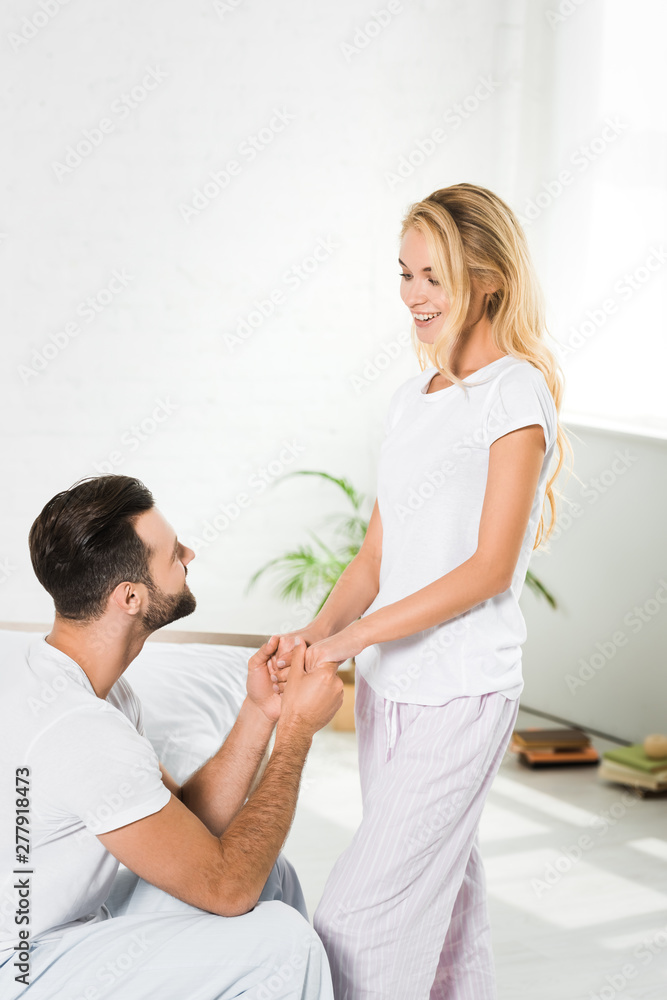 beautiful happy couple in pajamas holding hands at home beautiful happy couple in pajamas holding hands at home