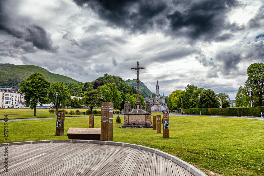 Naklejka premium Christian cross on a background the Basilica of our Lady of the Rosary in Lourdes, France