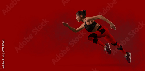 Sporty woman running. Red background