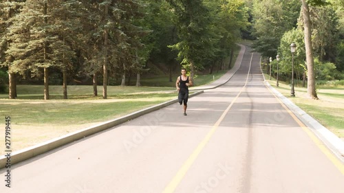 Wallpaper Mural Man running in Park sunny day Follow shot video. Sportsman Runner Athlete training  Torontodigital.ca