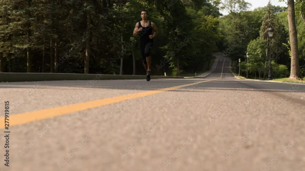Man running in Park sunny day Follow shot Bottom view video. Sportsman Runner Athlete training Man running in Park sunny day Follow shot Bottom view video. Sportsman Runner Athlete training