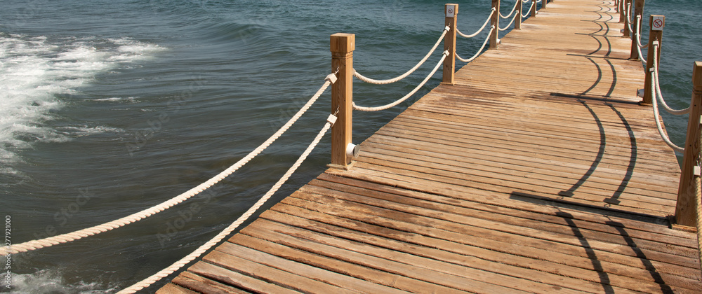 Fototapeta premium Scene at Tropical Beach Resort with wooden pier and rope