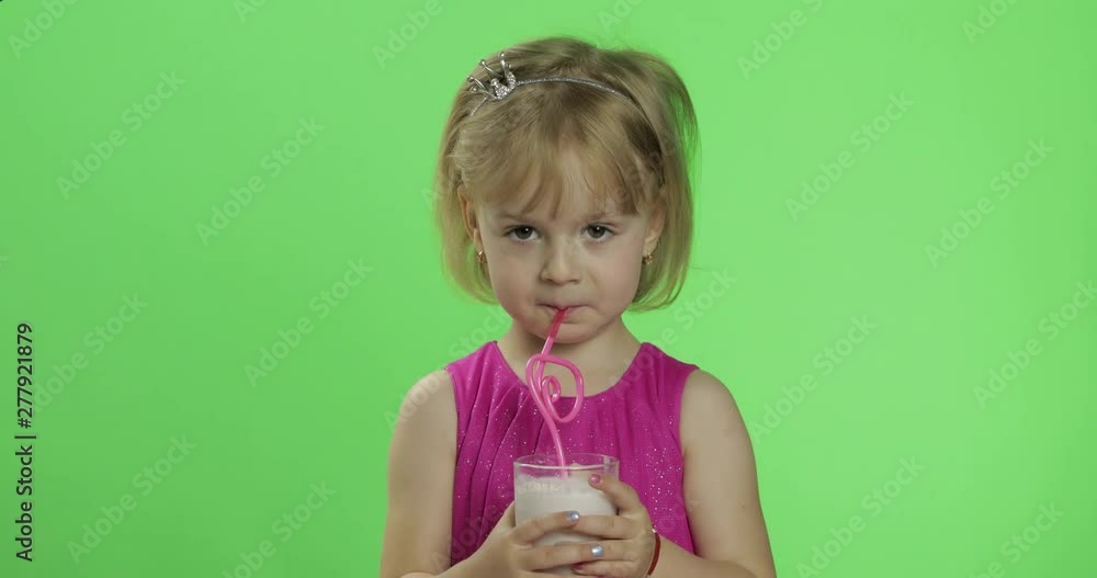 Happy four years old child in pink dress drinks milkshake cocktail. Chroma Key