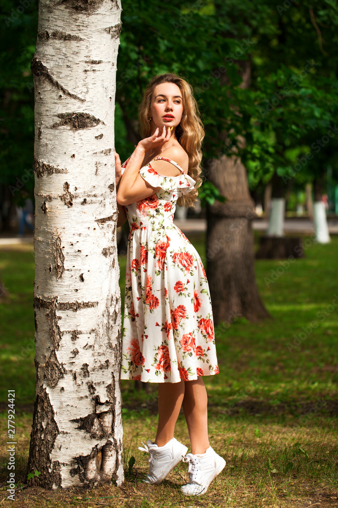 Pretty sexy young blonde woman in white dress posing in summer park Pretty sexy young blonde woman in white dress posing in summer park