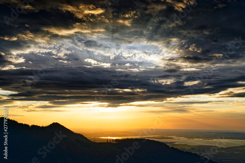 Beautiful sunset over lake Chiemsee with cloudy sky on Hochfelln mountain