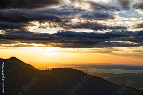 Beautiful sunset over Chiemsee lake with cloudy sky on Hochfelln mountain