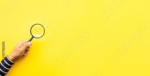 Valokuva Searching concepts with male hand using magnifying glass on yellow space backgro