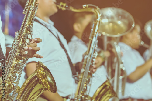 Photography Male student with friends blow the saxophone with the band for performance on stage at night