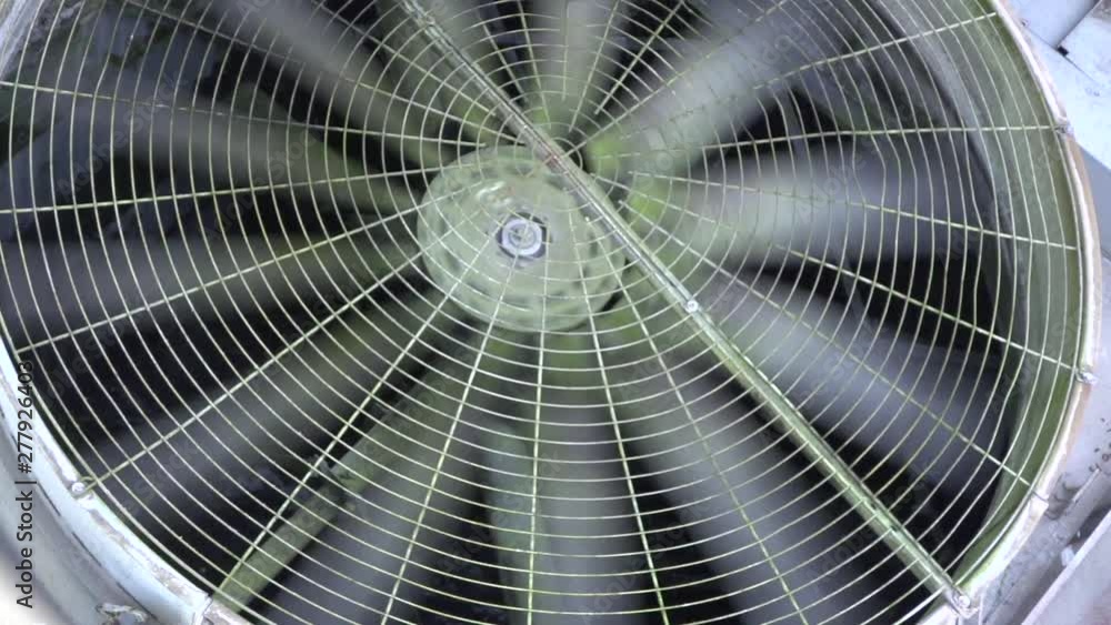 Large building air conditioning unit fan blades spinning slow motion