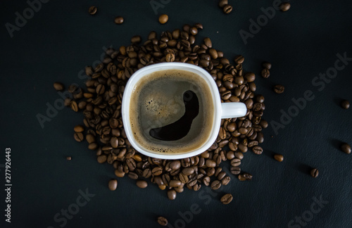 cup of coffee with beans on black background
