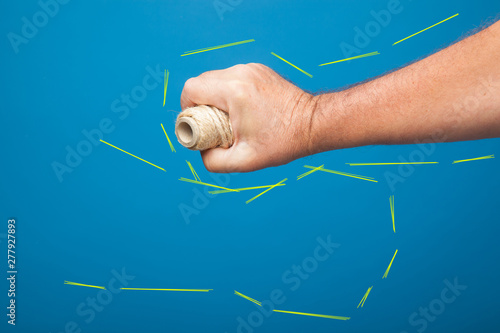 Rollo de cuerda cogido y sujetado por el puño de una mano derecha. Mano derecha coje un rollo de cuerda.