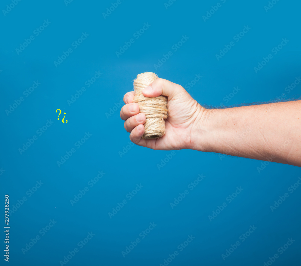 Rollo de cuerda cogido y sujetado por el puño de una mano derecha. Mano  derecha coje un rollo de cuerda. Stock Photo | Adobe Stock