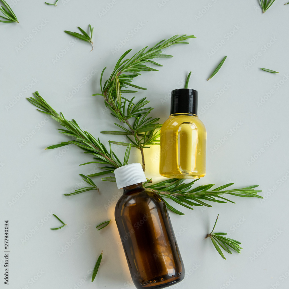 Bottles with rosemary essential oil. Herbal cosmetic treatment products. - obrazy, fototapety, plakaty 