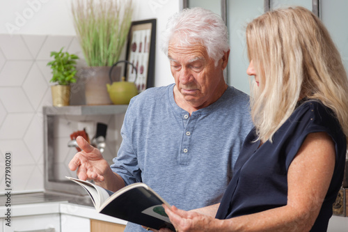 COUPLE SENIOR LISANT UN LIVRE photo