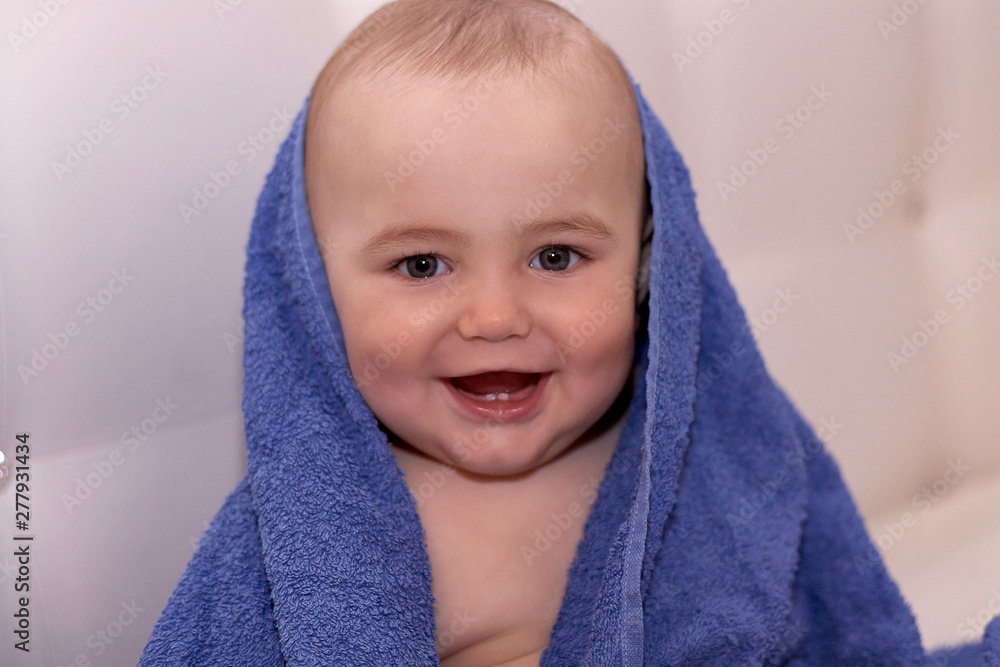 Baby after bath sits wrapped in a towel Baby after bath sits wrapped in a towel
