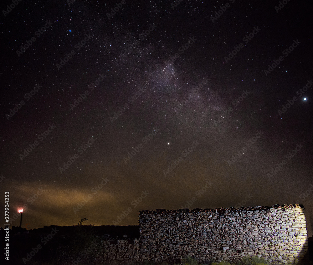 Milky way with an old stone house