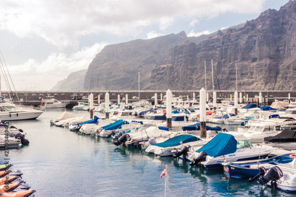 Pier Los Gigantes. Sailing and motor boats, steep rocks. Tenerife island, Spain