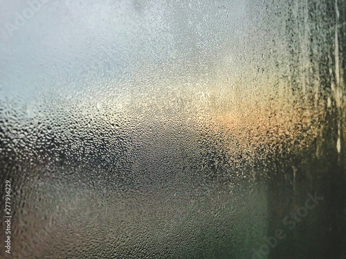 Transparent glass in the mist from the humidity in the air in cool tones on the background blurred. Surface of blue condensation, morning at Phuket International Airport
