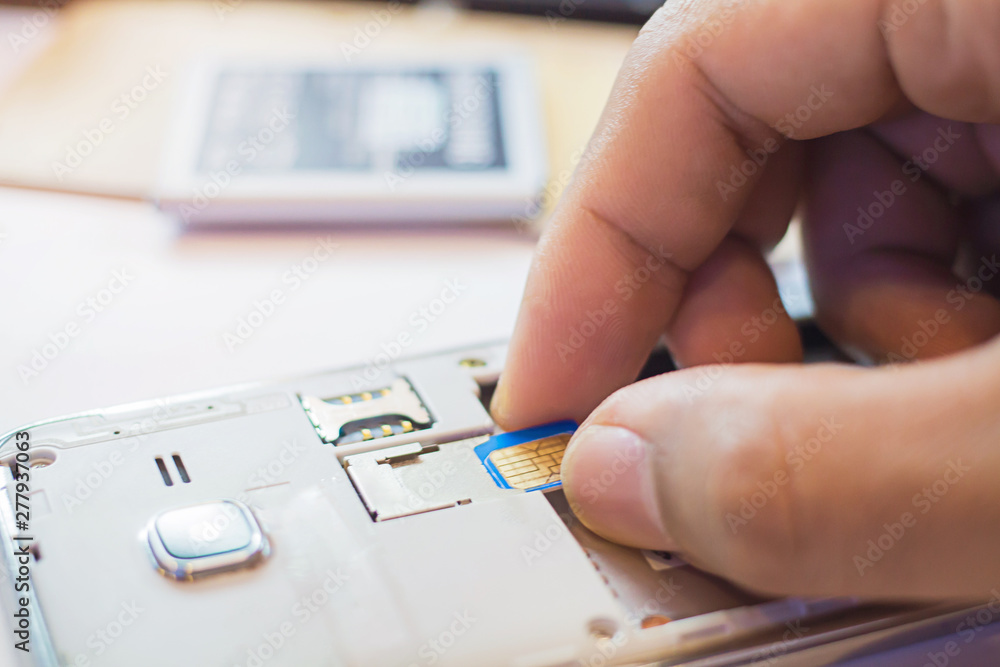 Employees are putting nano SIM cards in the store for customers to buy,Men's hands, changing the SIM card. Time to travel