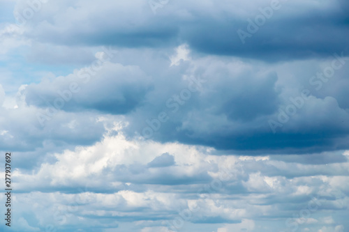 Cumulonimbus clouds on a summer blue sky. Time before a thunderstorm. Abstract background