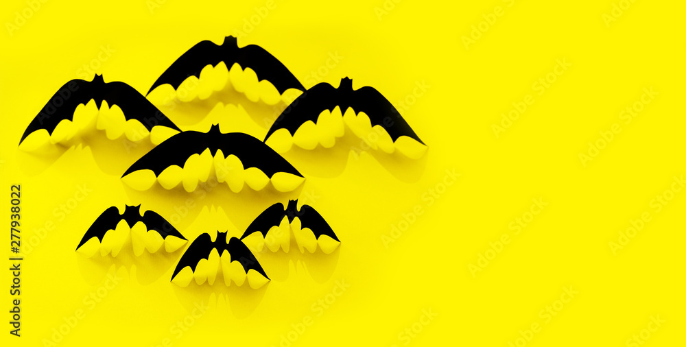 Minimalistic Paper bat pattern with falling shadow on yellow background. Halloween decorations banner. Halloween concept. Flat lay, top view, copy space.